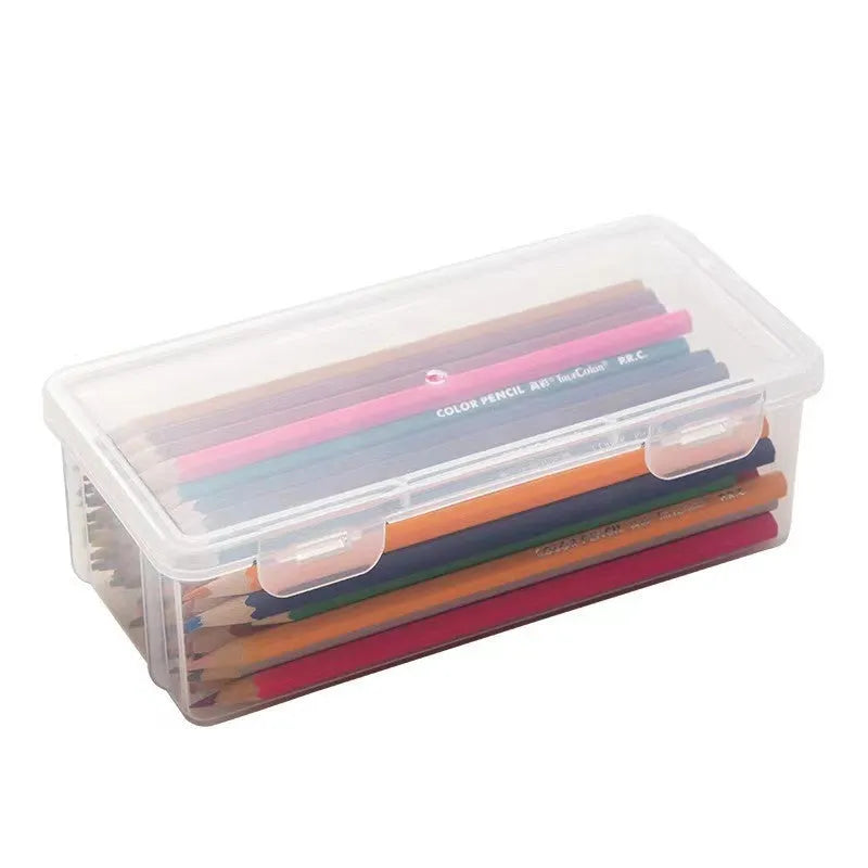 Clear plastic storage box for pencils, colouring leads, and children's crayons on a desk.