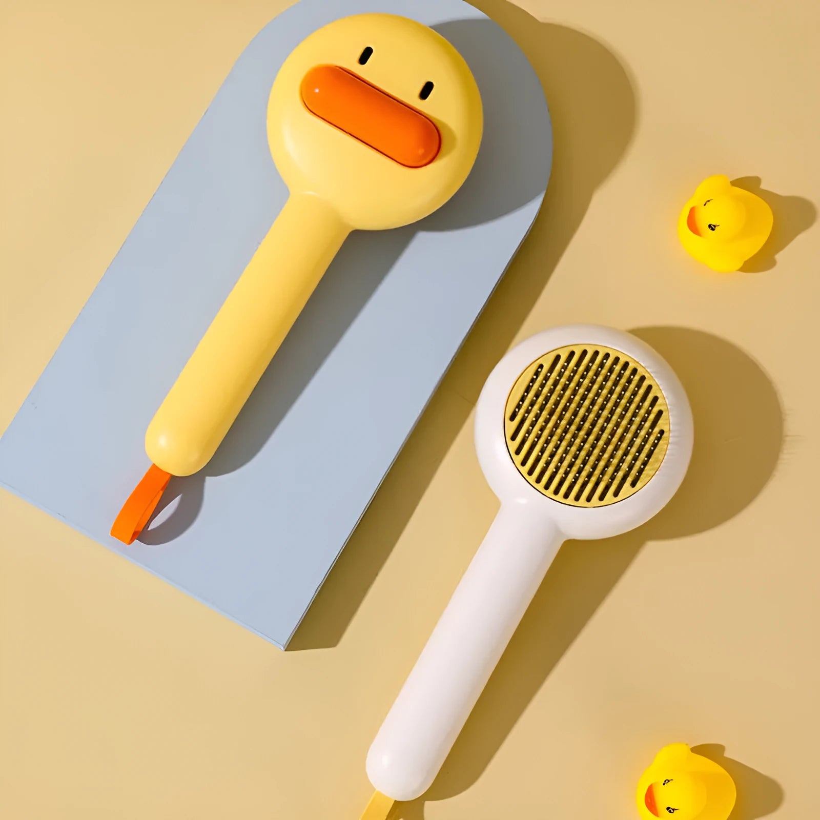Small yellow duck-shaped pet comb with open and needle teeth for grooming cats and dogs.