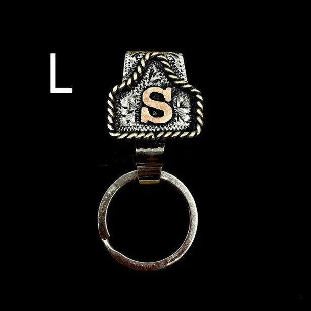Handmade metal cow tag belt keychain showing one of 26 colour options, each marked with a different alphabet letter.