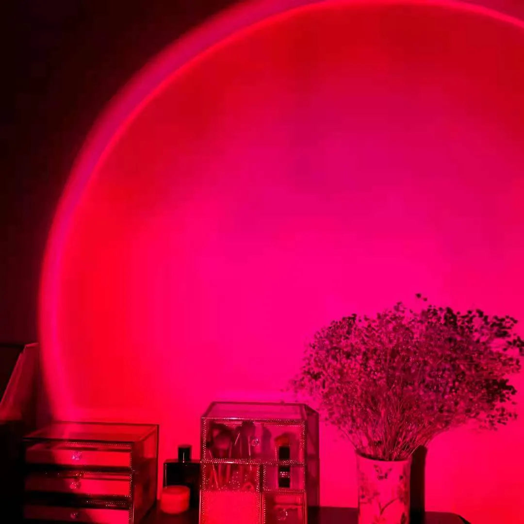 Rechargeable sunset projection lamp showing rainbow colour patterns with USB power cable