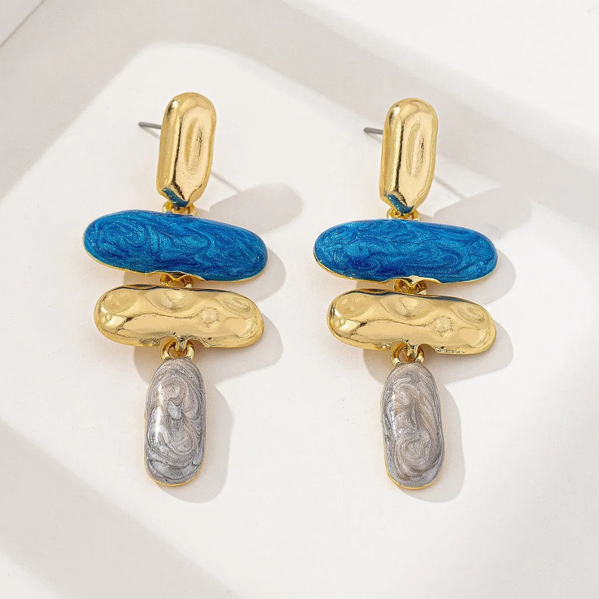 A pair of simple geometric stud earrings with a multicolour electroplated finish on a zinc alloy base.