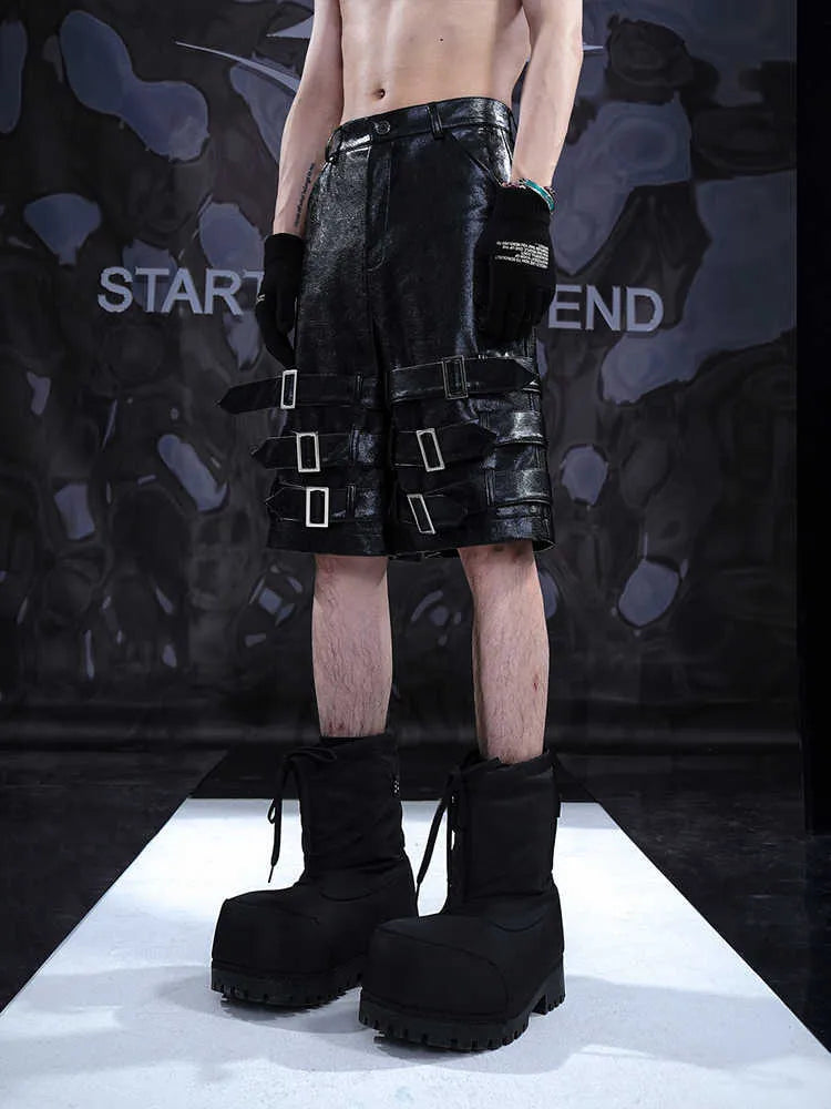 Black men's PU leather cropped shorts with a ring detail on the leg, shown on a model.