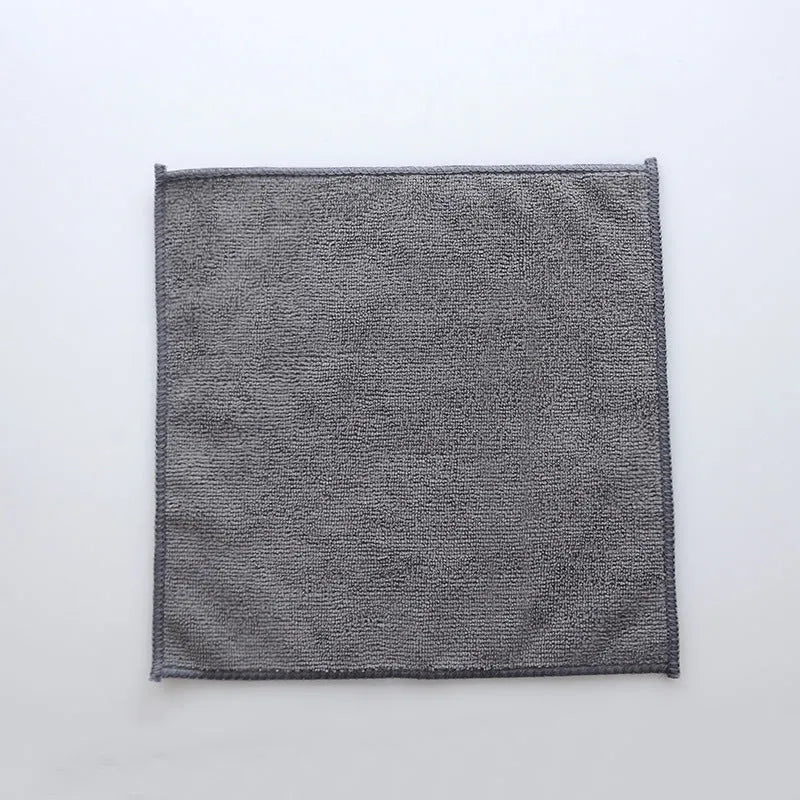 Grey square microfiber kitchen cleaning cloth for oil and grease removal on pots.