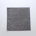 Grey square microfiber kitchen cleaning cloth for oil and grease removal on pots.