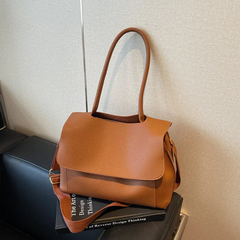 A brown PU tote bag with double shoulder straps and visible sewing thread detail.