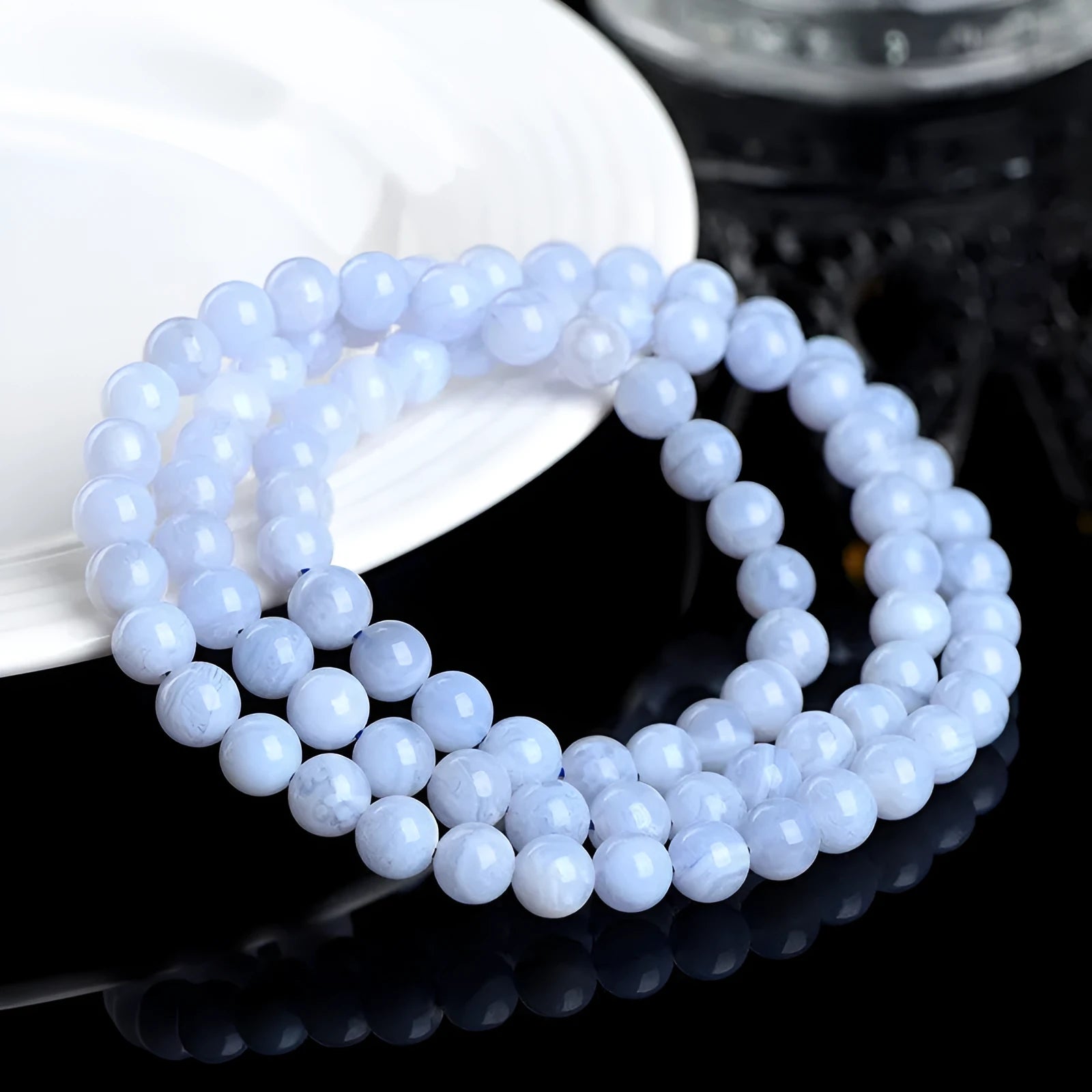 Blue agate bracelet with scattered multi-circle stripes and Ruyi design on wrist.