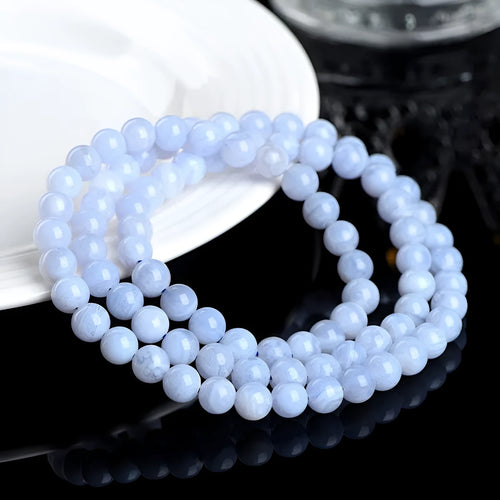 Blue agate bracelet with scattered multi-circle stripes and Ruyi design on wrist.