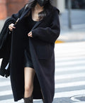 Long grey knitted hooded cardigan trench coat with loose fit on a model.