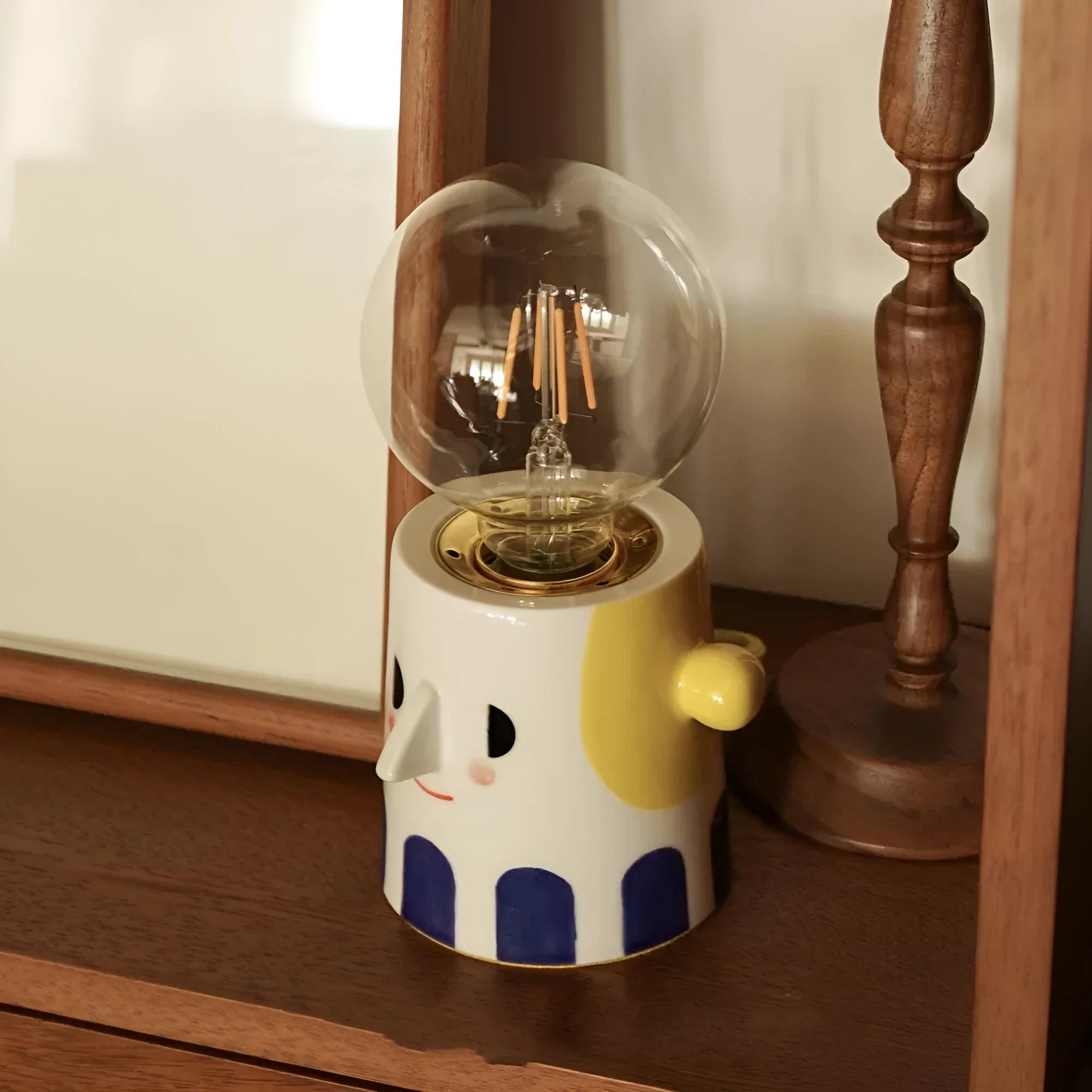 Handmade ceramic bedside lamp with ball headlight shade on wooden surface