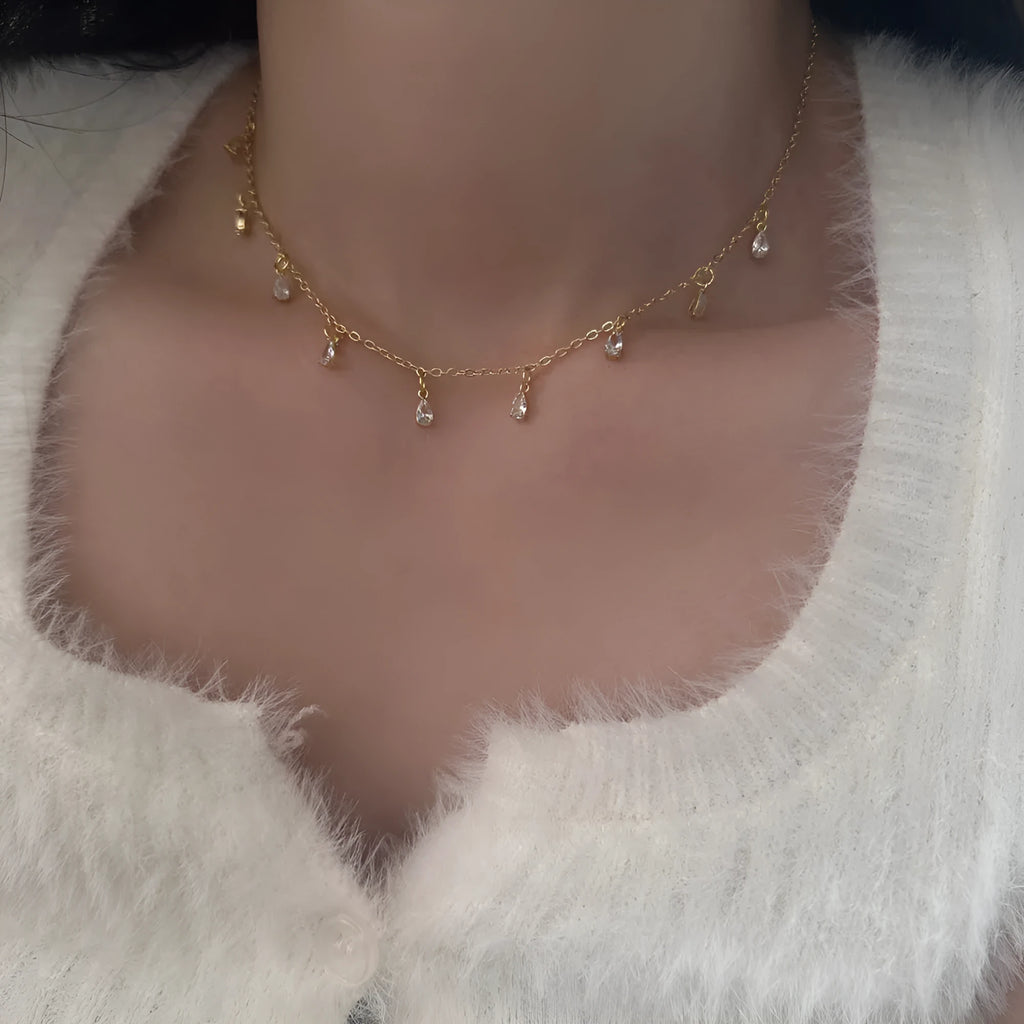 Women's zircon jewellery set showing geometric necklace, earrings, and anklet with meteor shower detail.