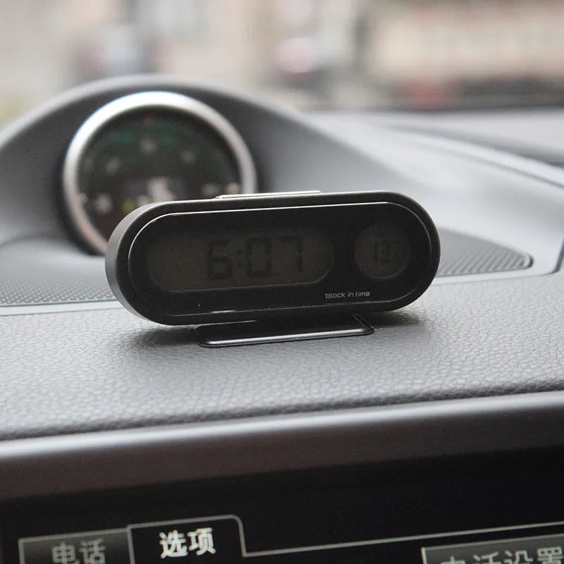 Black car digital clock thermometer with luminous display on adjustable bracket showing time and temperature
