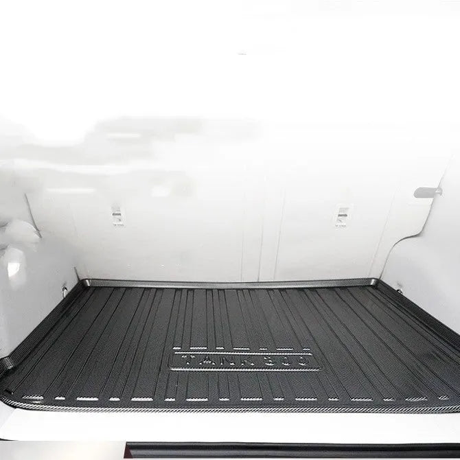 Black carbon fibre pattern TPE car trunk protector mat lying flat.