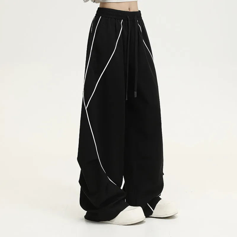 Black striped pleated hip hop sports wide-leg pants on hanger showing loose fit and mid-waist design