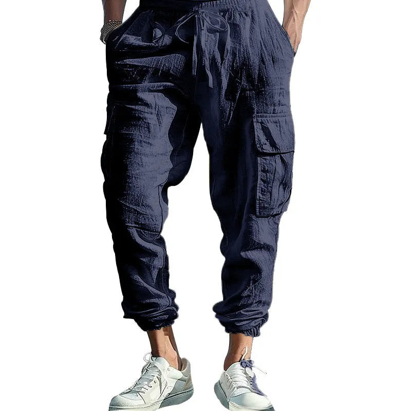 Man wearing khaki linen casual trousers with ankle-tied cuffs and multiple pockets.