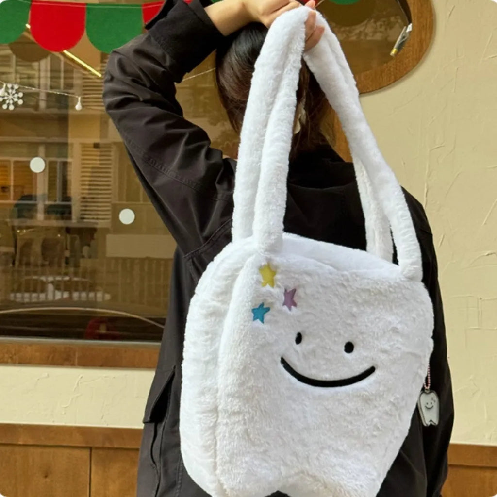 White plush large tooth shoulder tote bag with crossbody strap and zip closure.