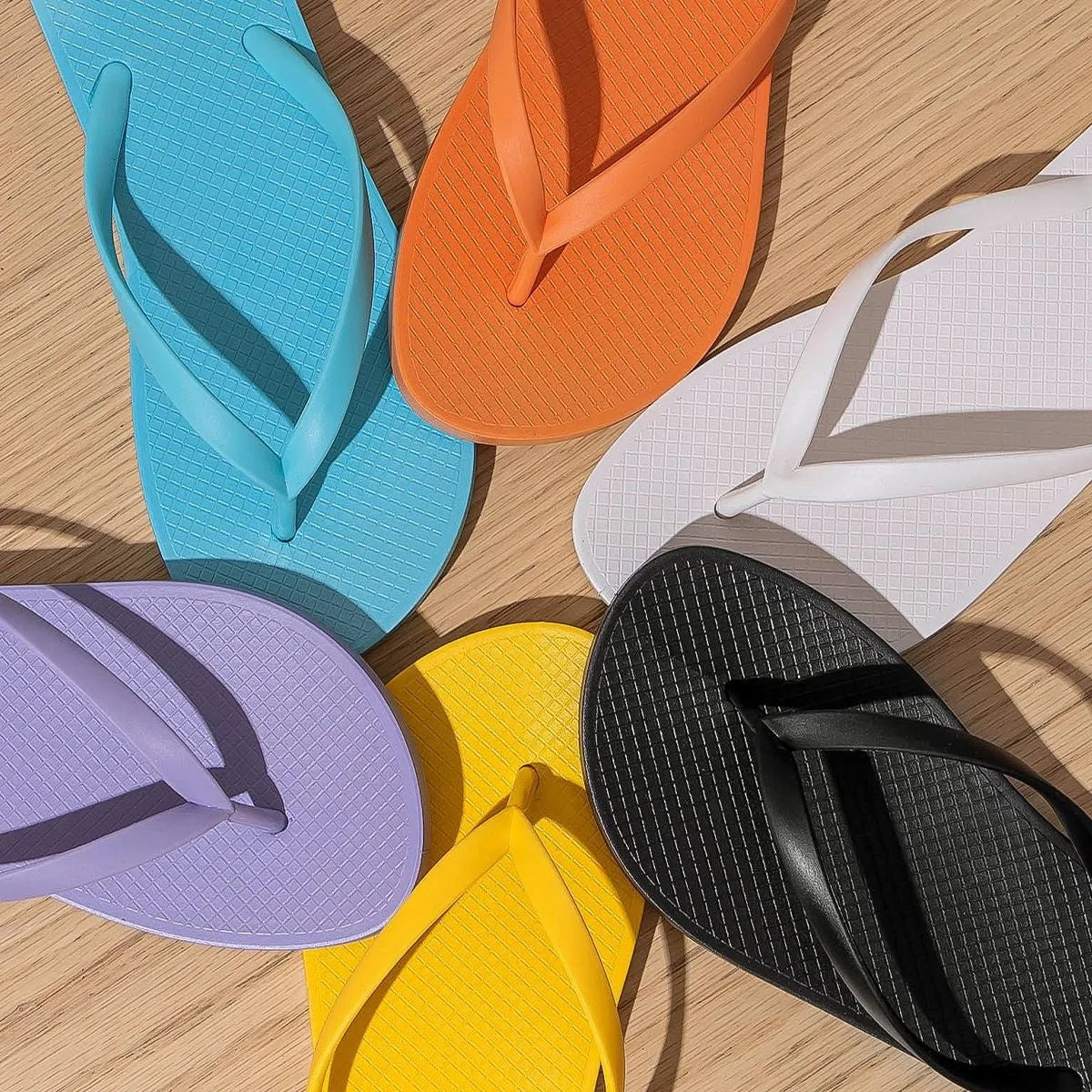 Orange foldable casual slippers with hollow-out plastic uppers and a textured PVC non-slip sole.