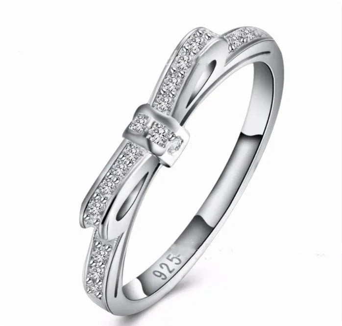 Silver couple style ring with bow shape decorated with rhinestone and zircon crystals.