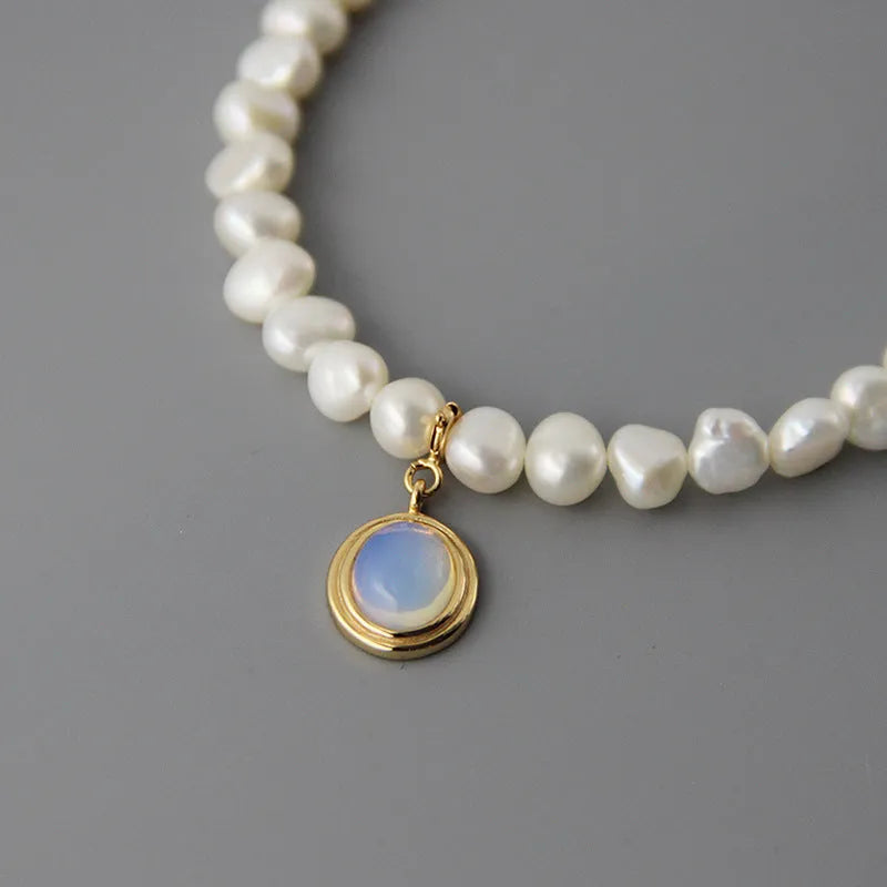 Silver necklace with round medal pendant and irregular freshwater pearls on adjustable chain