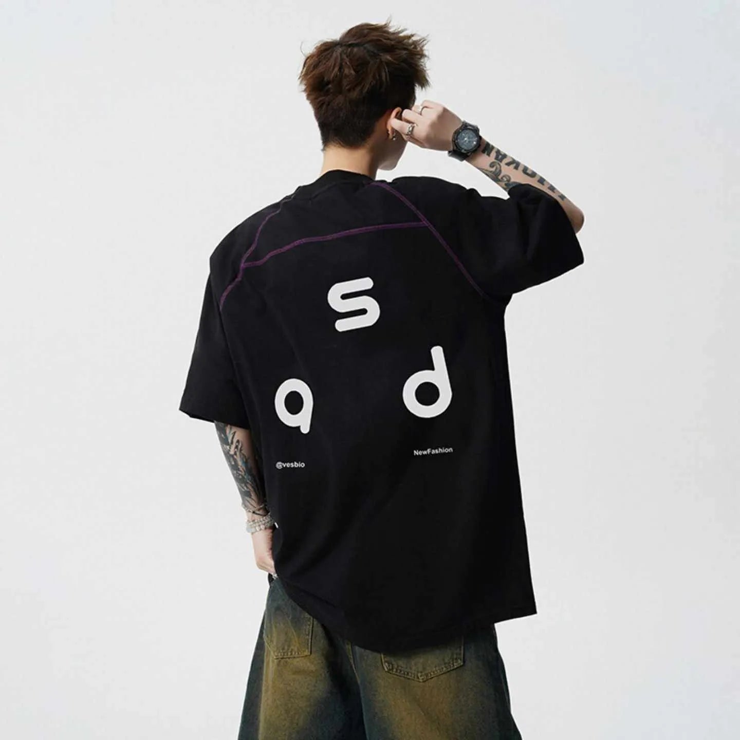 Loose fit black cotton t-shirt with white letter print, short sleeves, and round neck.