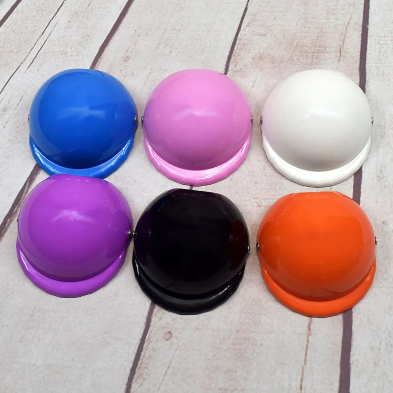 Plastic dog motorcycle cap helmet in various colours and sizes on a table