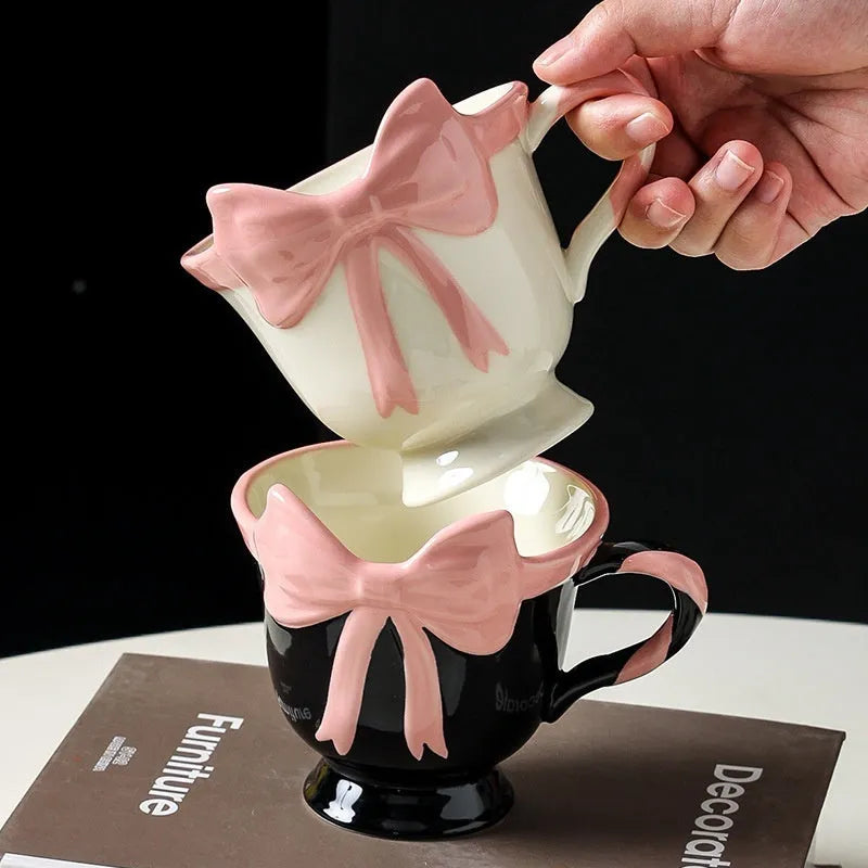 Ceramic mug with a decorative heart bow design in black pink or white powder colour.