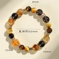 Close-up of a yellow artificial crystal beaded bracelet with 10mm Jinba beads on a wrist.