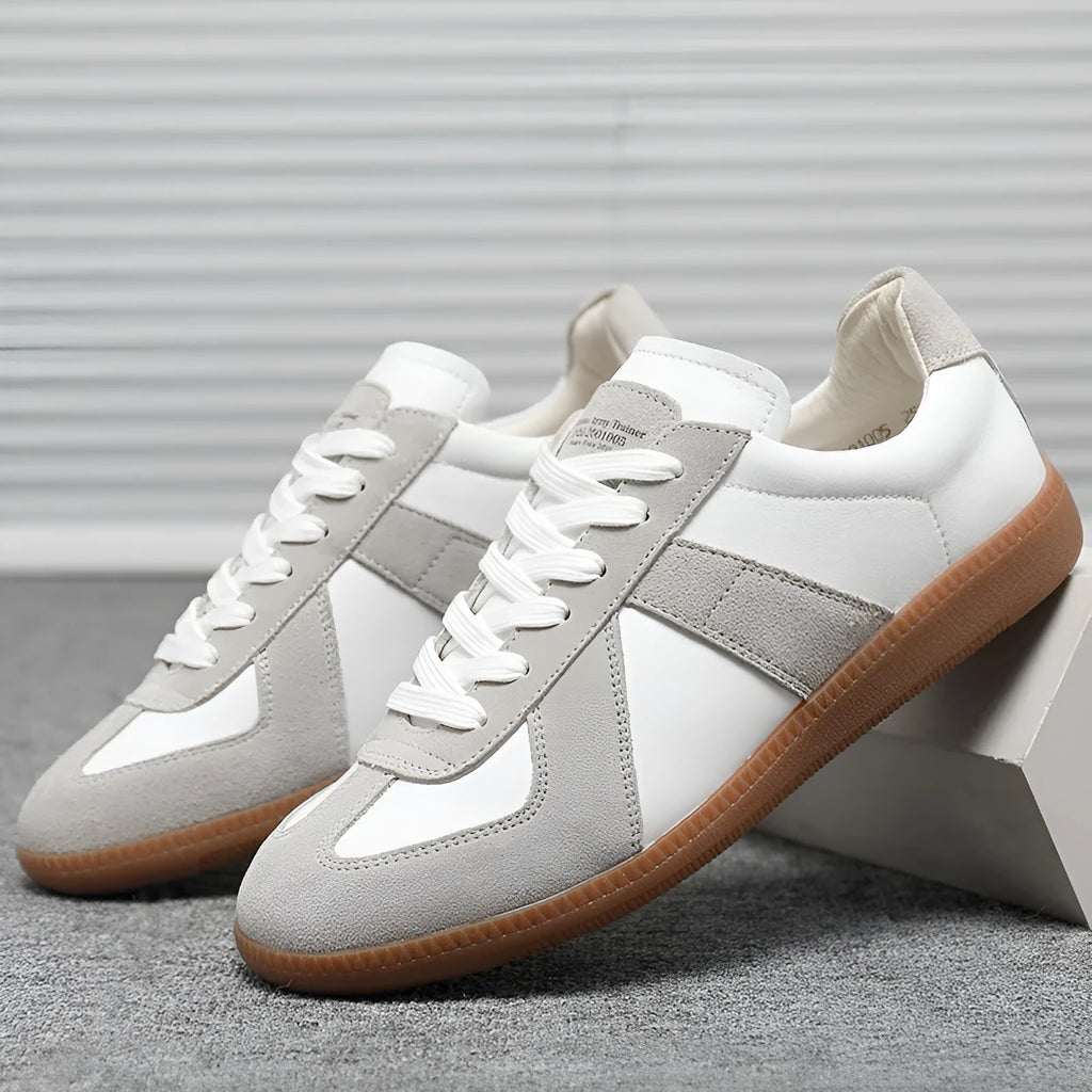 Men's low top white retro sneakers with round toe and flat rubber sole on a plain background