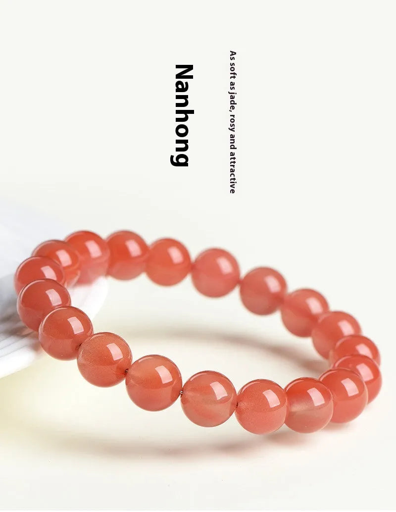 Natural South cherry red agate bracelet showing polished stone beads in scattered arrangement