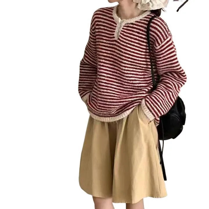Woman wearing a loose red and blue striped cashmere pullover sweater with long sleeves.
