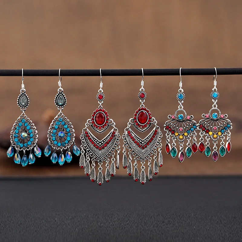 Long purple fringe drop earrings with retro crystal design on a white background.
