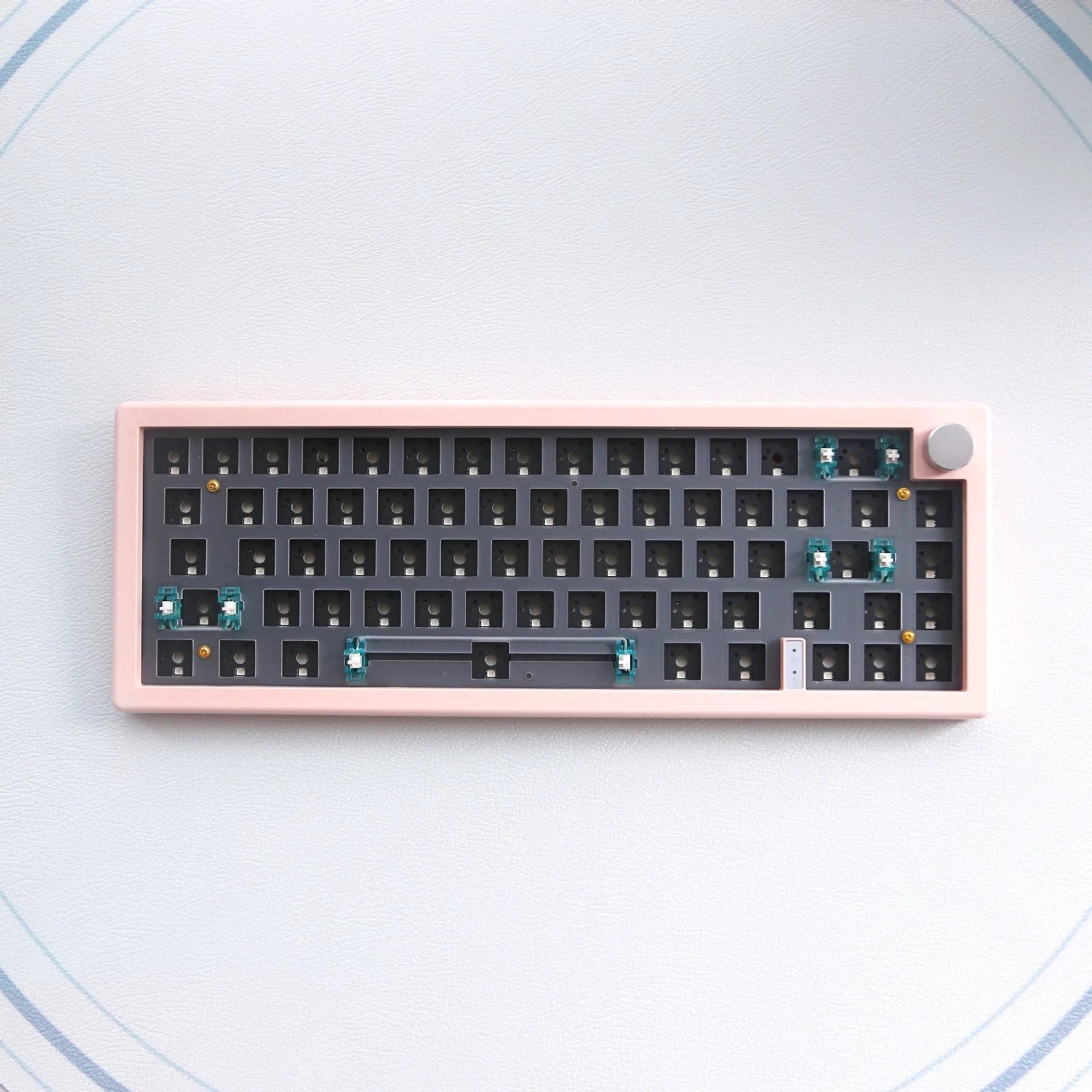 DIY mechanical keyboard kit components with RGB keys and knob on a black ABS case.