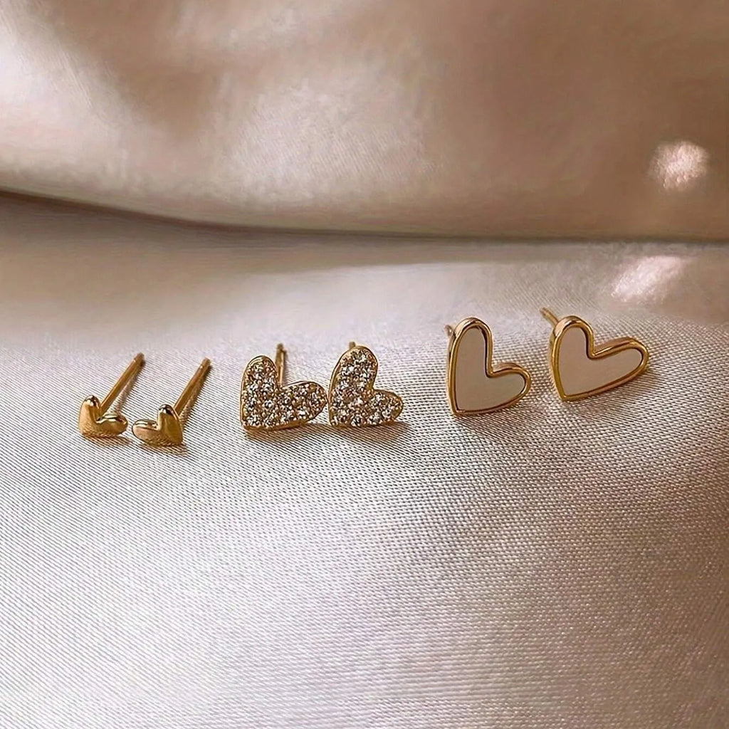 Three pairs of heart-shaped alloy earrings with electroplated finish in gold, black, and pink colours