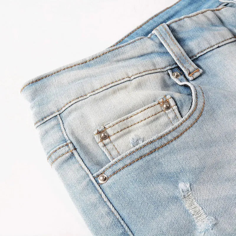 Men's light blue distressed slim fit jeans with five pocket patchwork, enzyme washed, side view