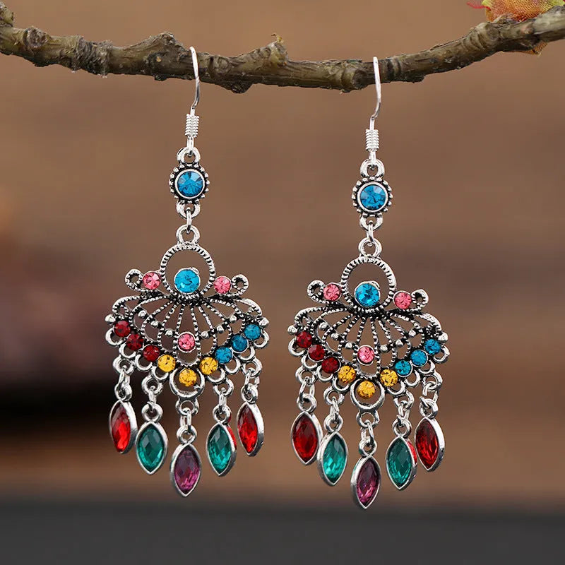 Long purple fringe drop earrings with retro crystal design on a white background.