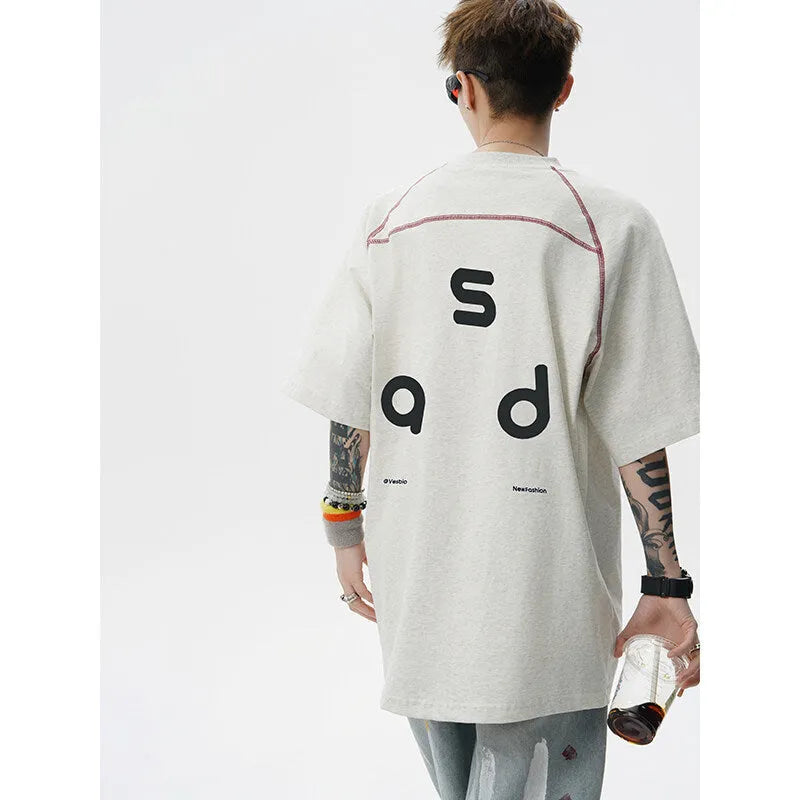Loose fit black cotton t-shirt with white letter print, short sleeves, and round neck.