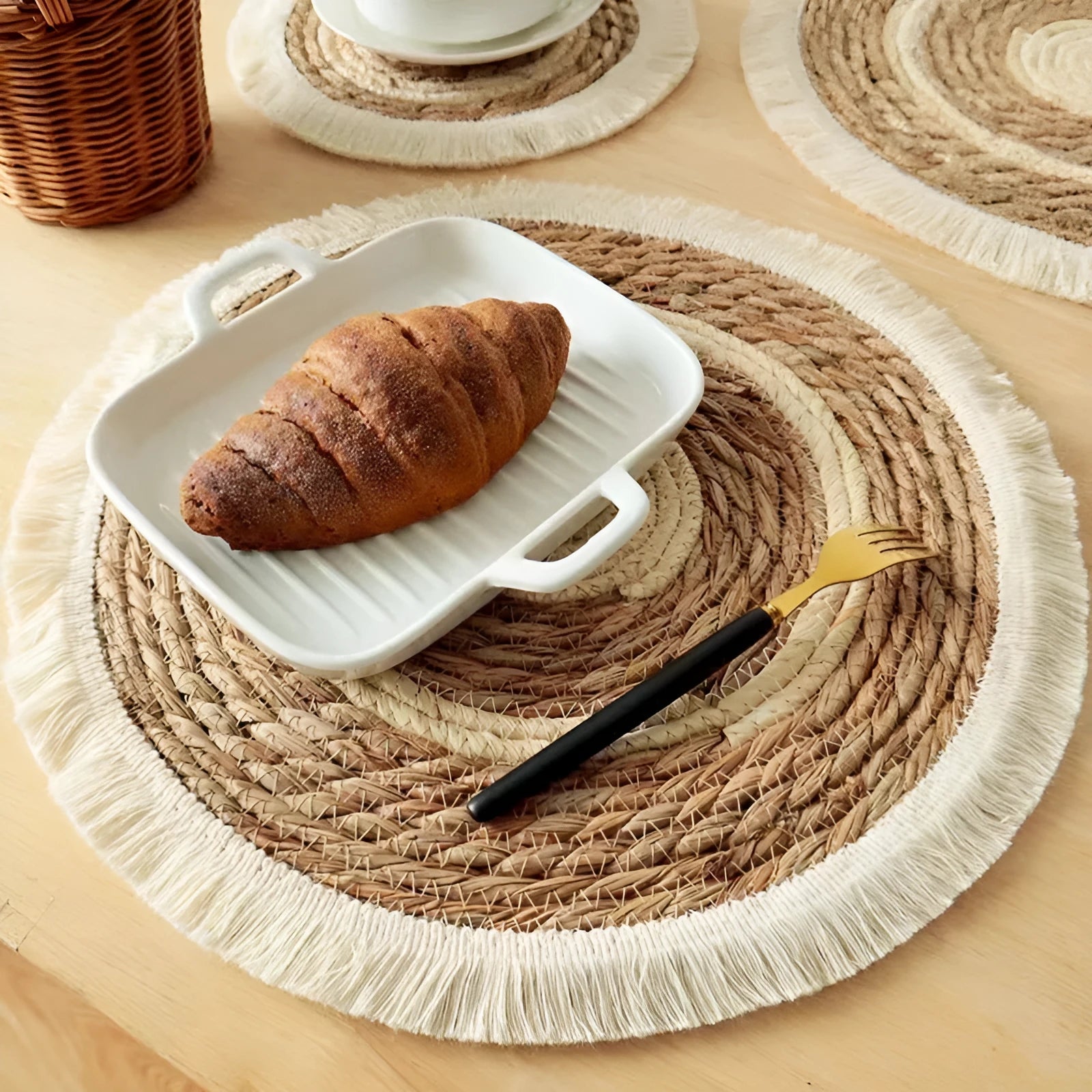 Round Japanese straw placemat with corn rope tassels in natural papyrus colour on wooden table