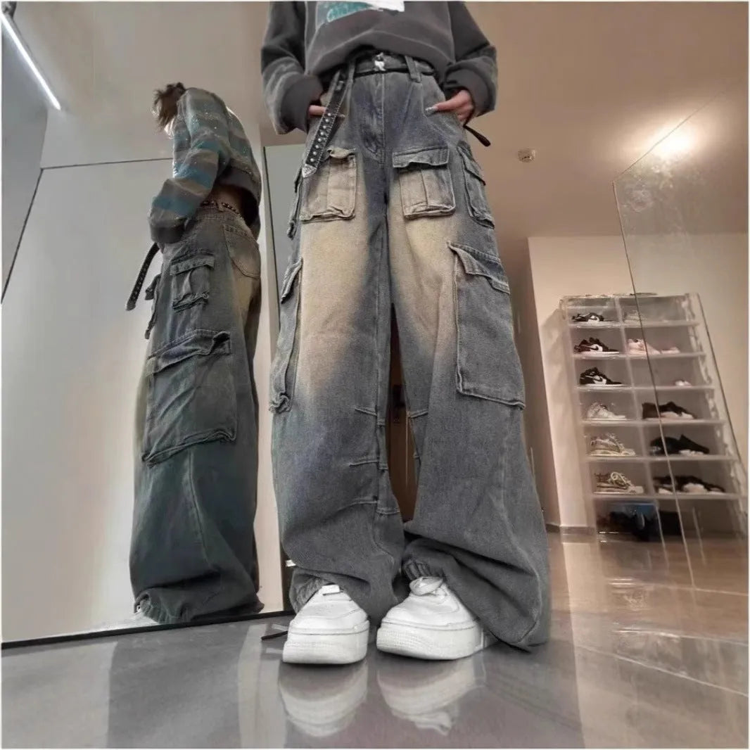 Loose-fit light blue distressed denim jeans with multiple tooling pockets on a straight-leg cut