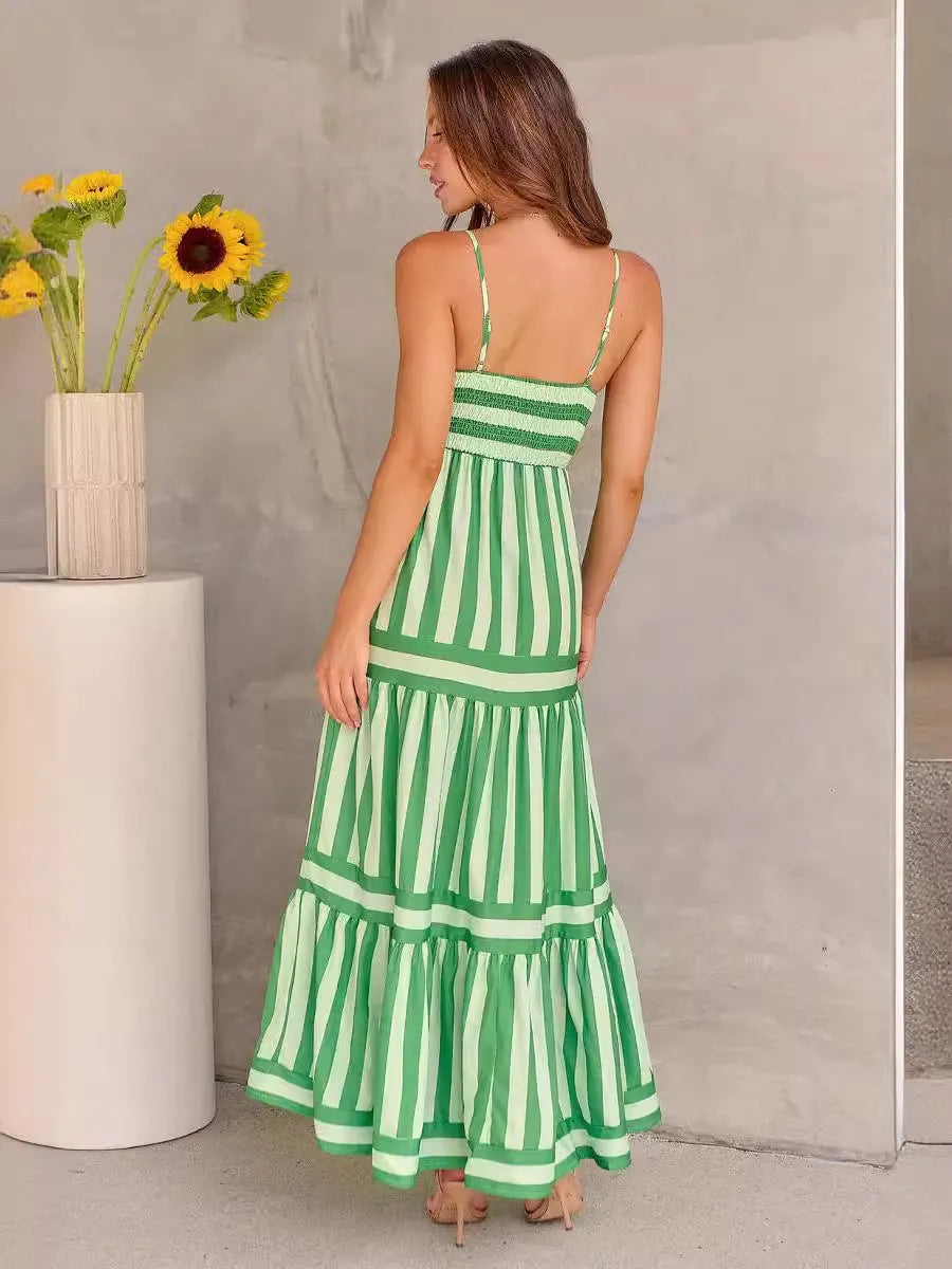 Woman wearing a striped backless suspender long dress with a square neck and side pockets.