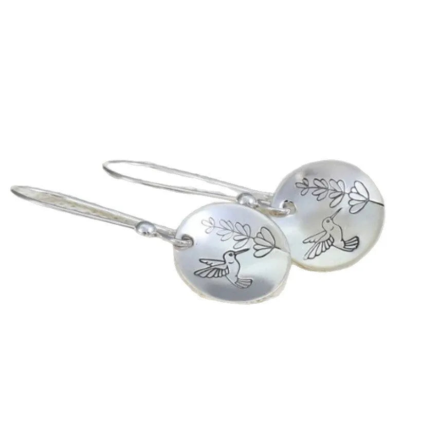 Silver round women's earrings with glossy finish showing bird and floral retro design details
