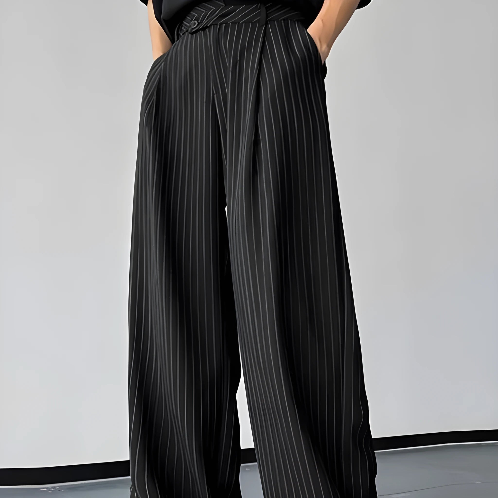 Men's black vertical striped pleated casual trousers laid flat.