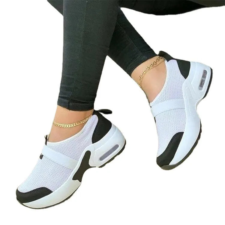 Women's white mesh flat sneakers with a round toe and rubber sole.