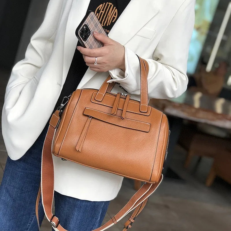 Soft black cowhide leather messenger bag with lychee pattern, showing internal phone and camera pockets.