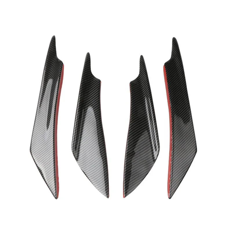 Set of four carbon fibre pattern bumper blade spoilers for car modification on a black background.