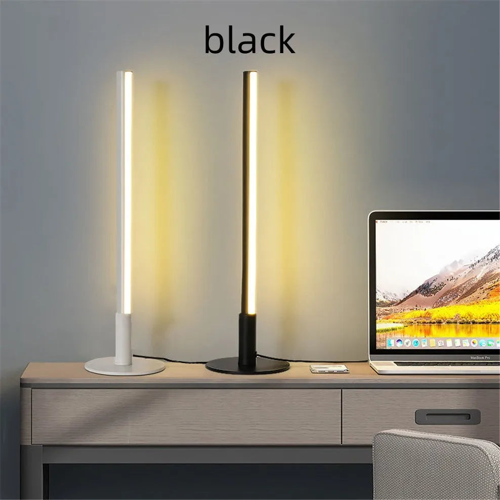Tall, cylindrical black aluminium alloy retro atmosphere lamp on a table.