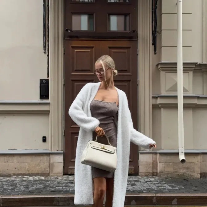 Women's long white knitted cardigan jacket with long sleeves shown open.