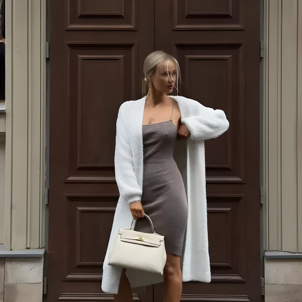 Women's long white knitted cardigan jacket with long sleeves shown open.