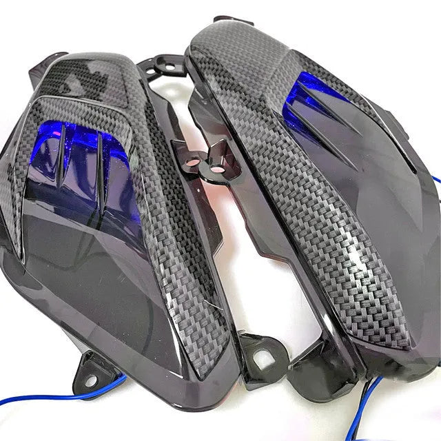Yamaha NMAX side lamp replacement kit showing ABS plastic shell, PVC lamp shade, and stainless steel screws