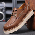 Men's black low-top Martin boots with a round toe and non-slip rubber sole on a plain background.