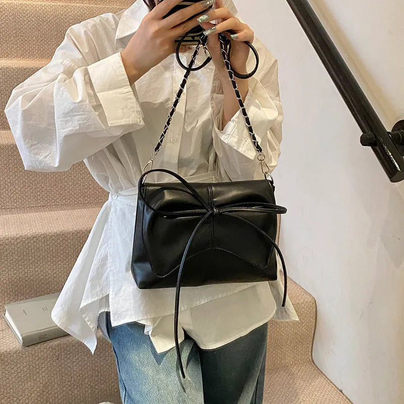 Women's black PU leather crossbody underarm bag with horizontal square shape and visible sewing lines.