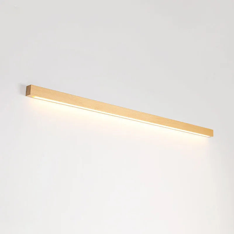 Modern walnut-coloured wood and acrylic log strip wall lamp in three lengths on a white wall.